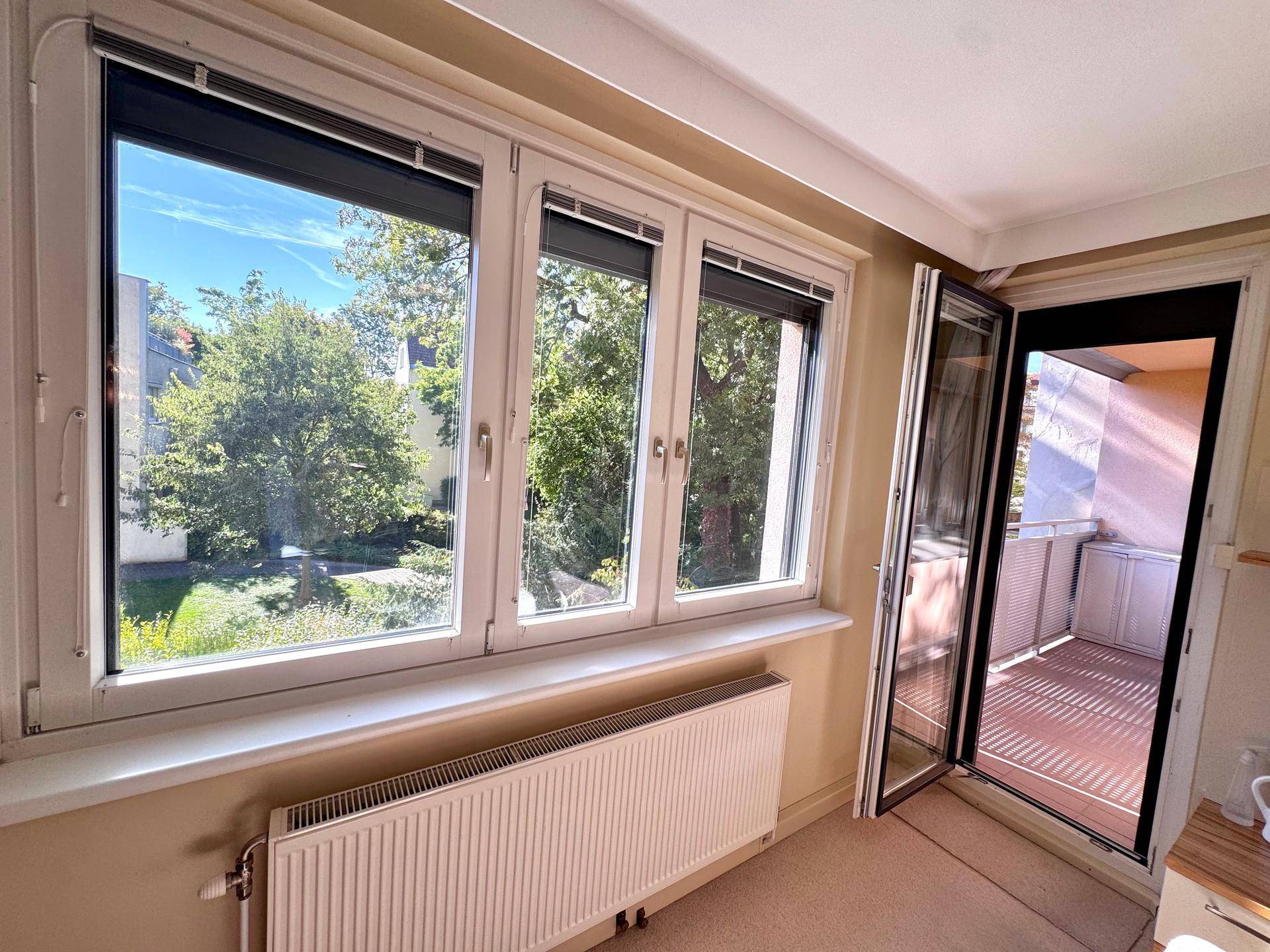 Heller Raum mit großen Fenstern und direktem Zugang zu einem sonnigen Balkon.