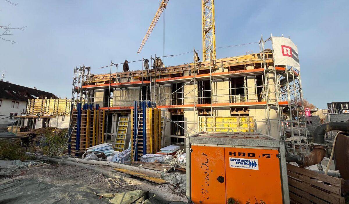 Rohbau eines Gebäudes mit Gerüst und Kran, Bauarbeiten schreiten auf der Baustelle voran.