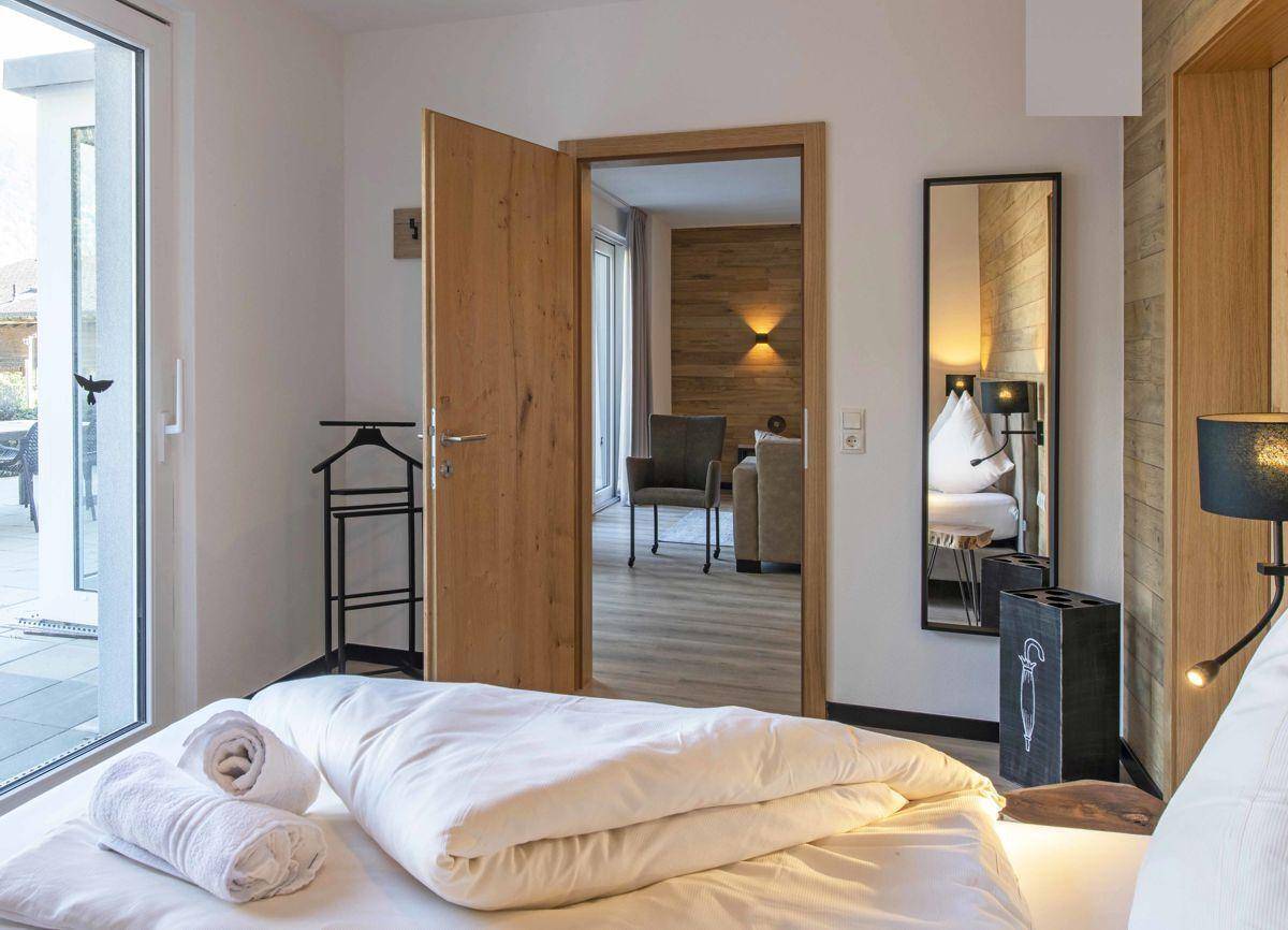 Helles Schlafzimmer mit Zugang zur Terrasse und Blick in den angrenzenden Wohnbereich.
