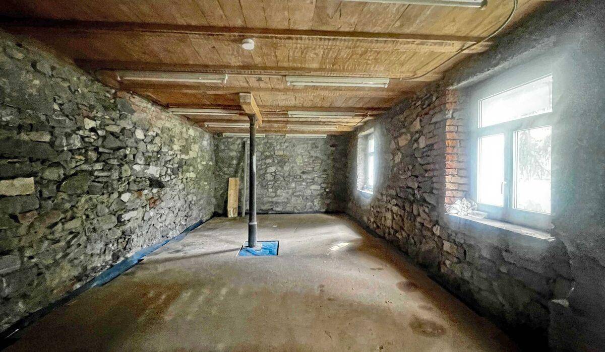 Geräumiger Kellerraum mit Steinwänden und Betonboden, ideal als Lagerfläche.