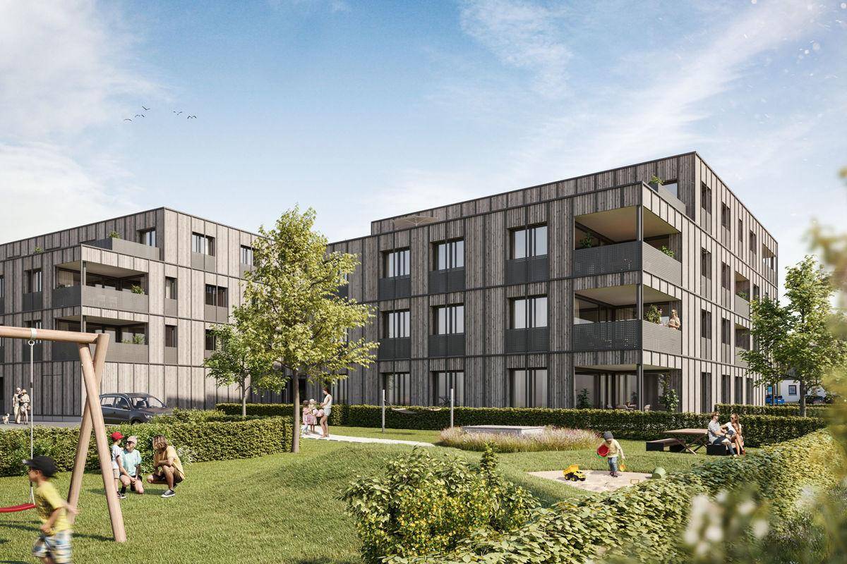 Moderne Wohngebäude mit Balkonen und einem Spielplatz in einer grünen Wohnanlage.
