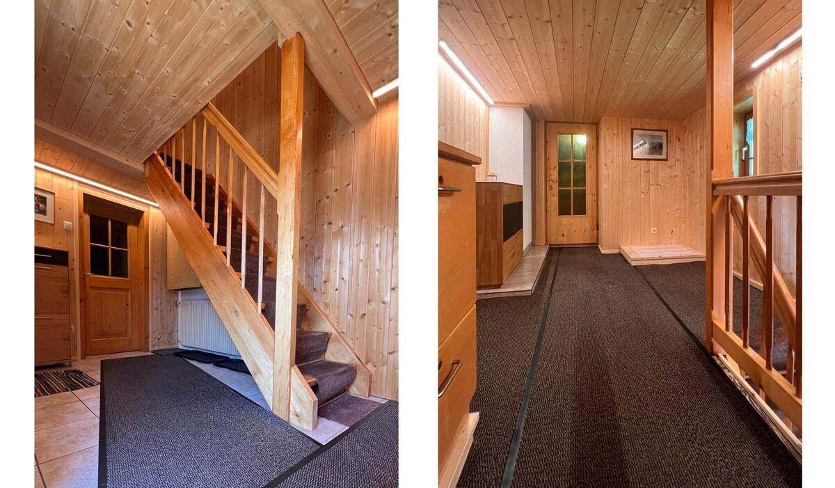 Holztreppe und Flur mit Teppichboden und Holztäfelung, die die oberen Etagen verbindet.