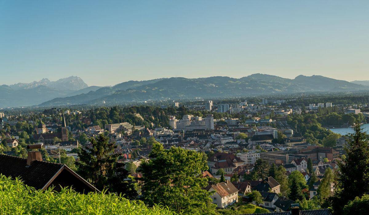Klarer Tageslichtblick über die Stadt und die beeindruckende Bergkette am Horizont.