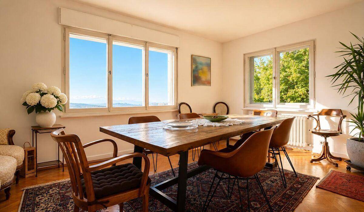 Helles Esszimmer mit Holztisch, modernen Stühlen und großen Fenstern mit weitem Landschaftsblick.