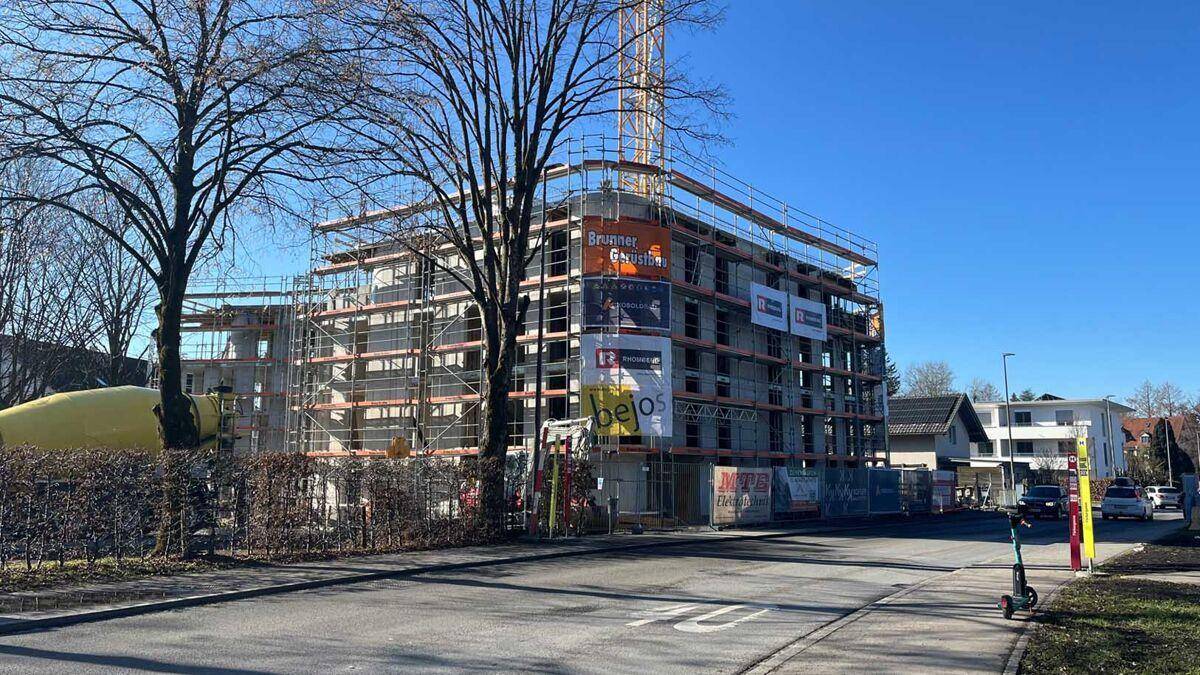 Seitenansicht der Baustelle eines Neubaus mit Gerüst und umliegender Straße.