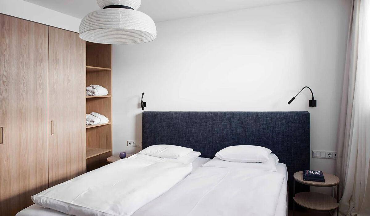 Helles Schlafzimmer mit Doppelbett, integriertem Kleiderschrank und Nachttischen.