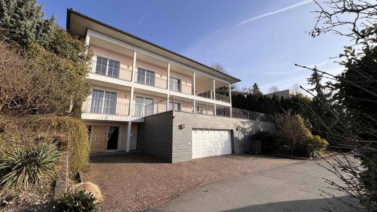 Ansicht der Villa von der Auffahrt mit Doppelgarage und gepflegter Umgebung.
