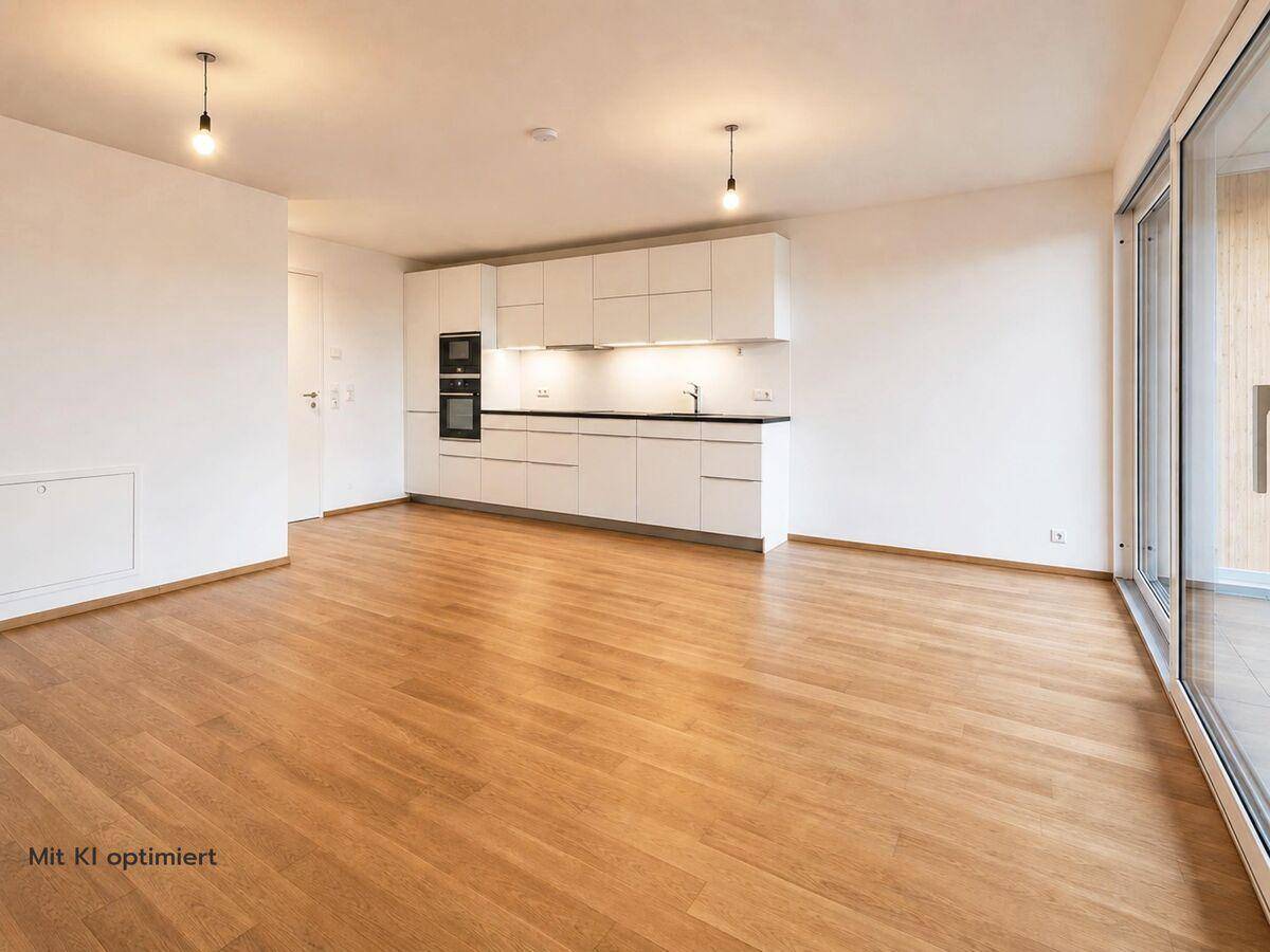 Geräumiger Wohn- und Essbereich mit moderner Einbauküche und hellem Holzfußboden.