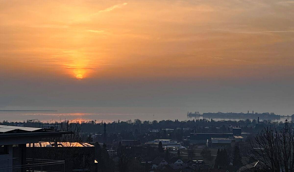 Malerischer Sonnenuntergang über der Stadt und dem See, gesehen von der Immobilie.