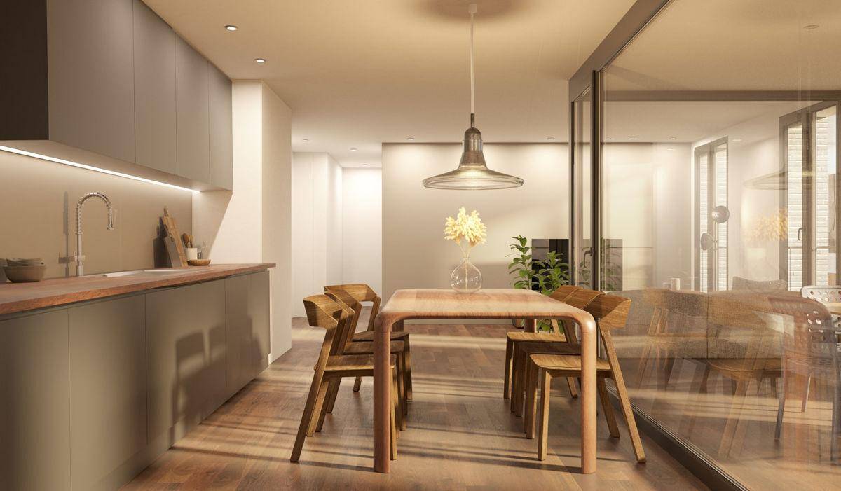 Moderne Küche mit grauen Schränken, Holzarbeitsplatte und Essbereich mit Holztisch.