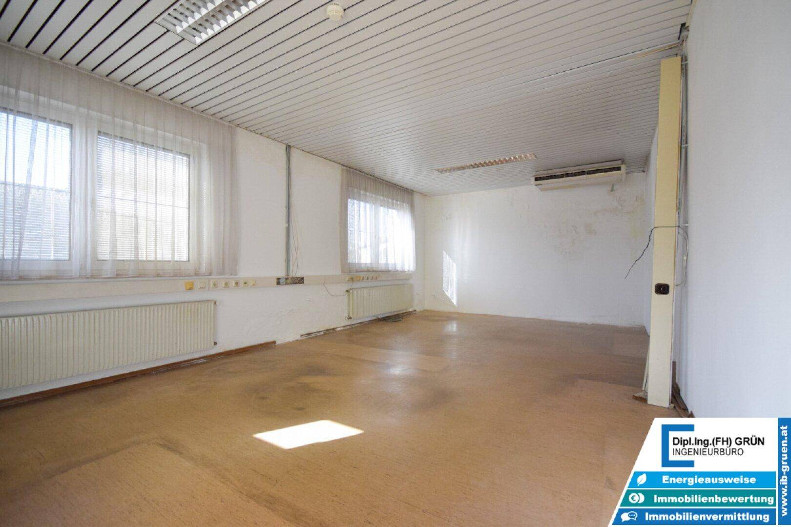 Großer, heller Raum mit mehreren Fenstern und Heizkörpern, ideal als Büro oder Arbeitsbereich.