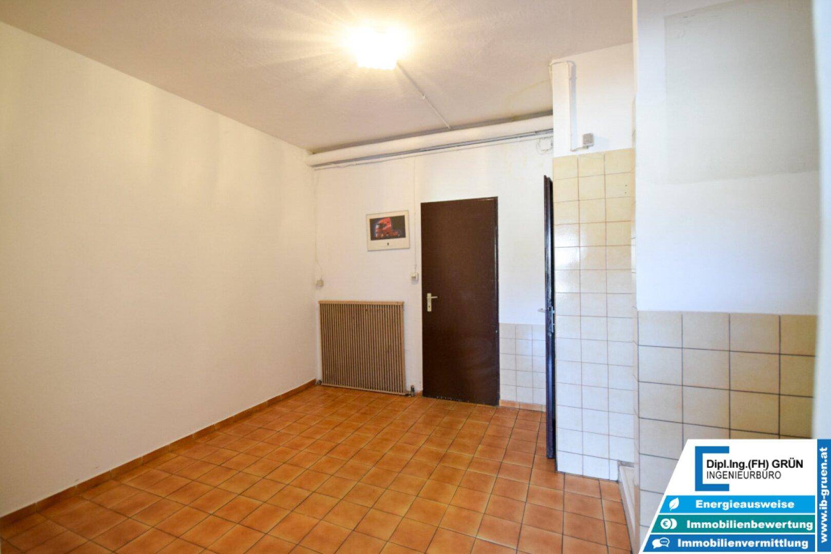 Einfacher Raum mit Terrakottafliesen und Heizkörper, teilweise gefliest, ideal als Abstellraum.
