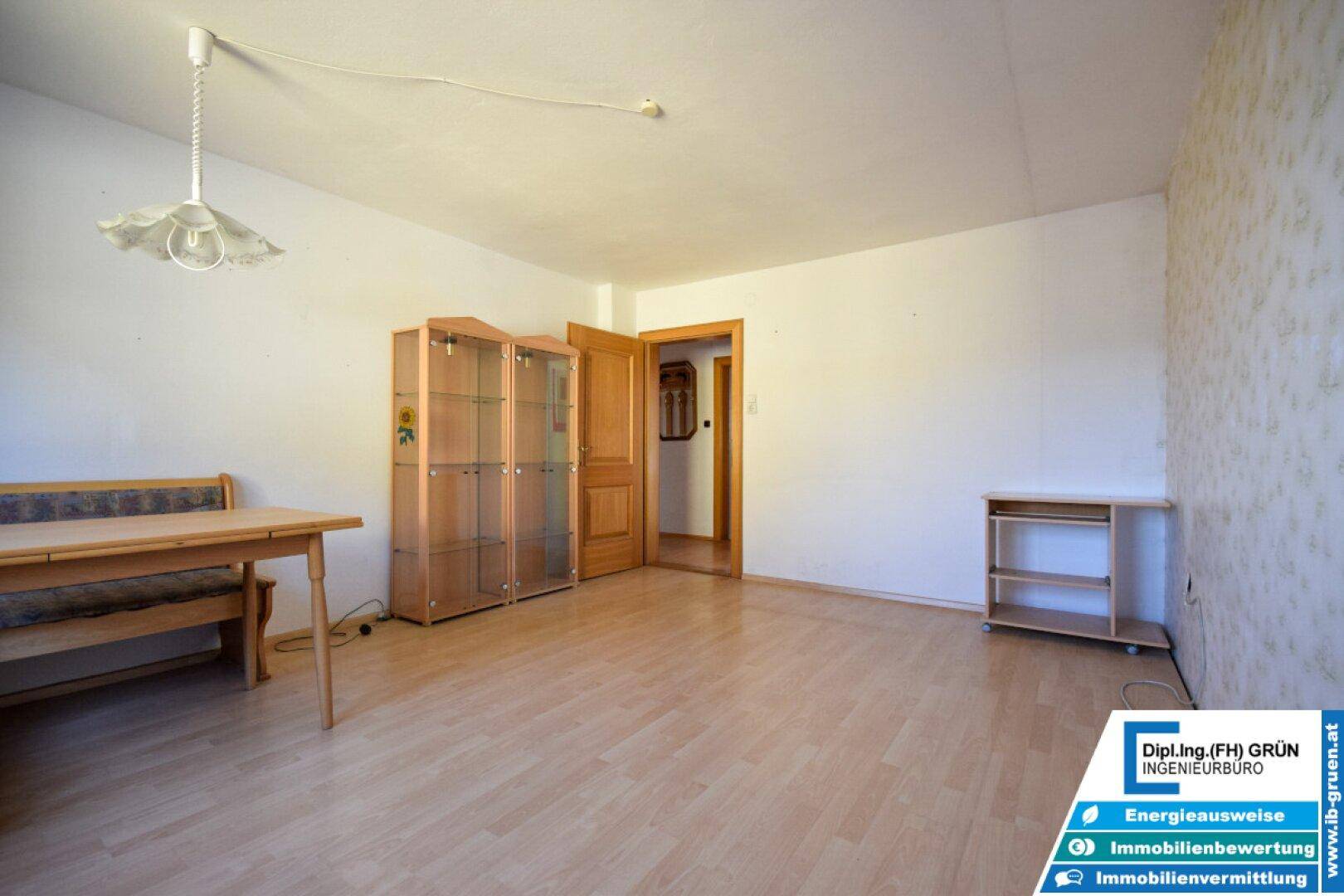 Geräumiges Esszimmer mit Laminatboden und Vitrinenschrank, ideal für Familienessen.