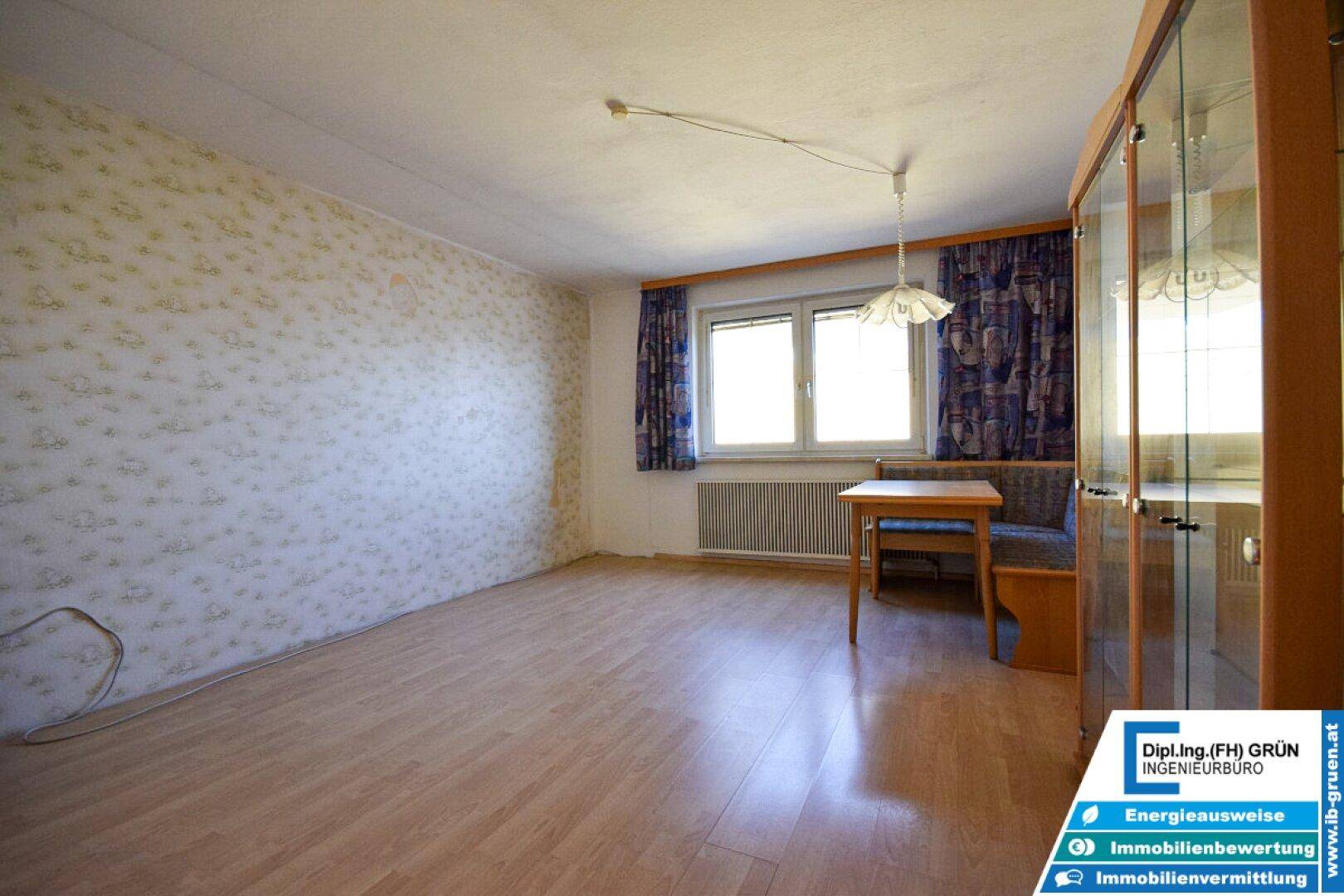 Esszimmer mit Laminatboden, Esstisch mit Bank und Fenster, hell und funktional.