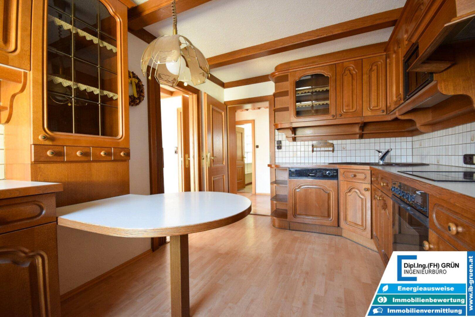 Gemütliche Holzküche mit traditionellen Schränken, Spülmaschine und Essbereich.