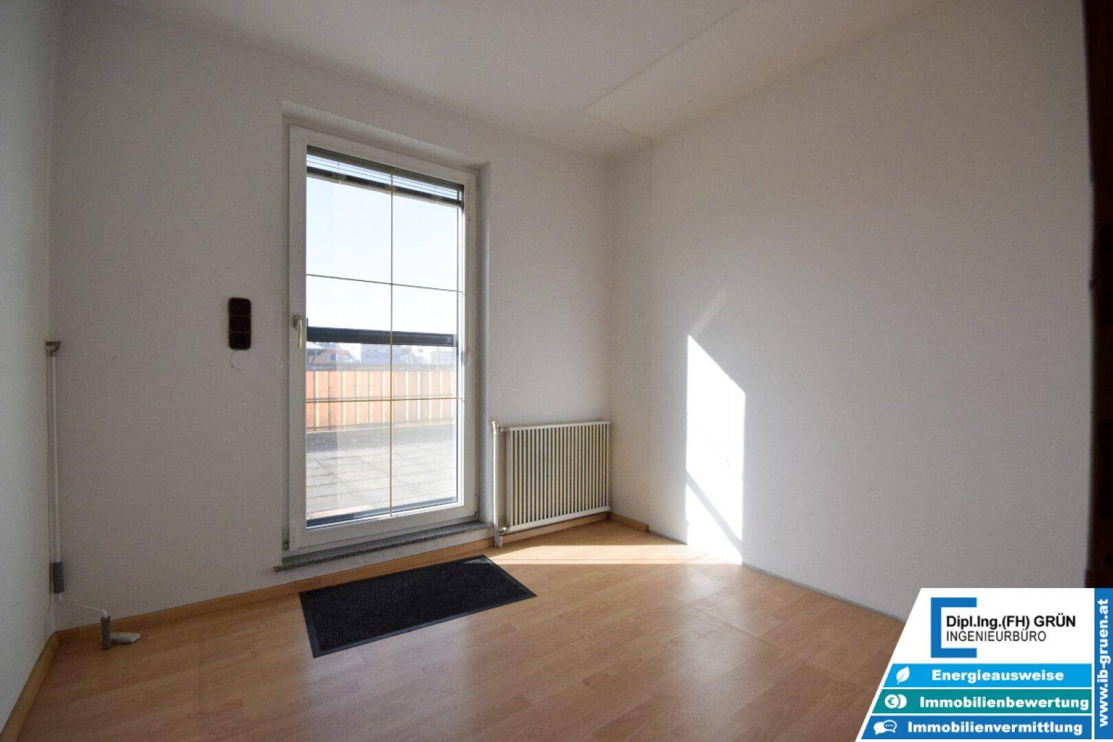 Kleiner Raum mit Laminatboden und großem Fenster, ideal als Büro oder Gästezimmer.