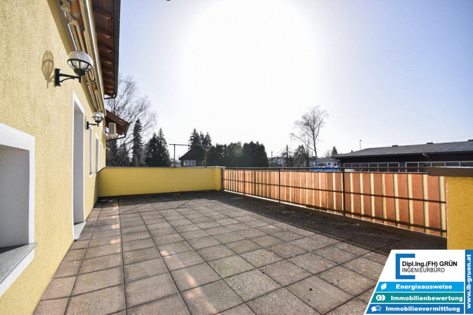 Große gepflasterte Terrasse mit Sichtschutz und sonnigem Ausblick.