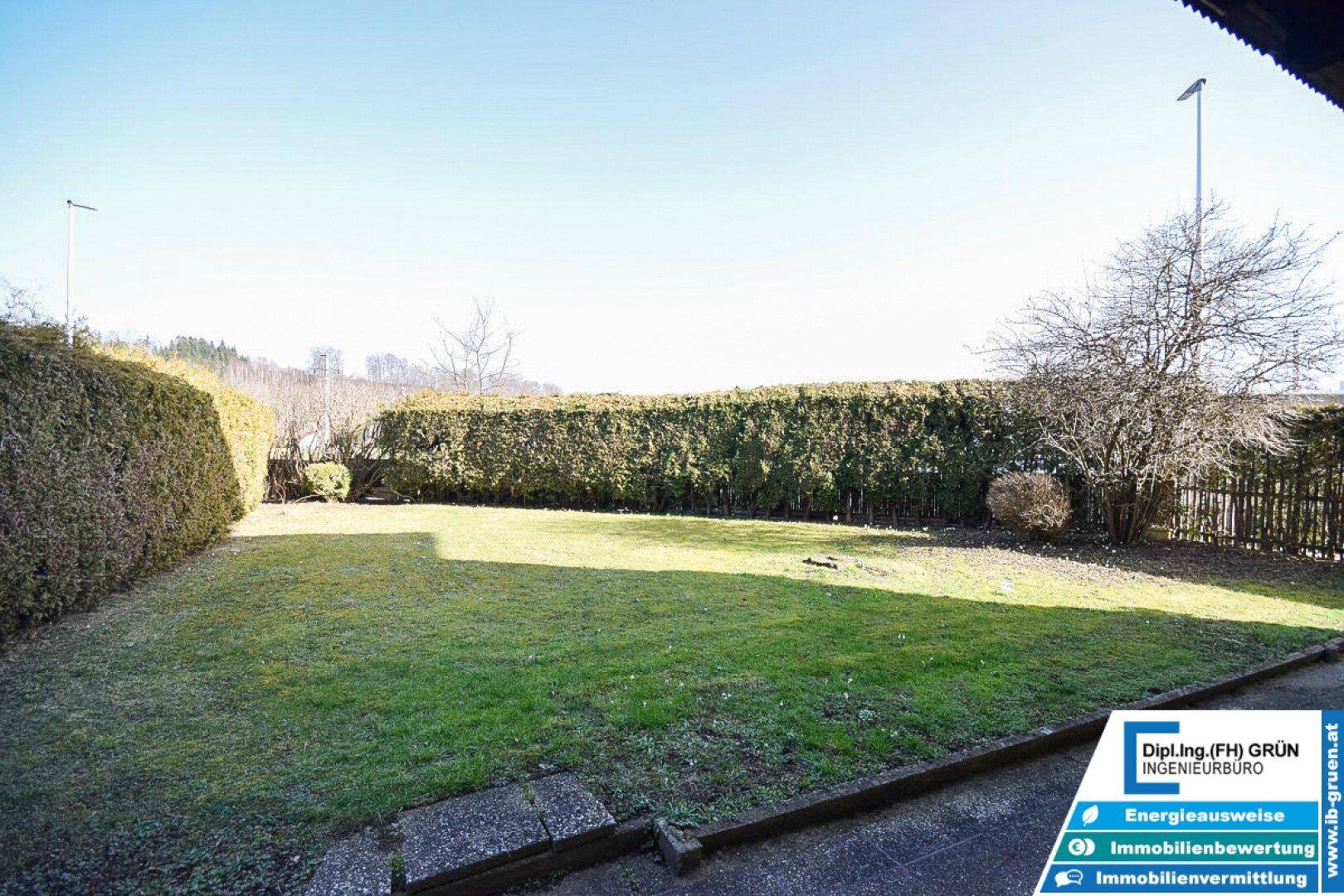 Weitläufiger Garten mit Rasen, hohen Hecken und freiem Blick.
