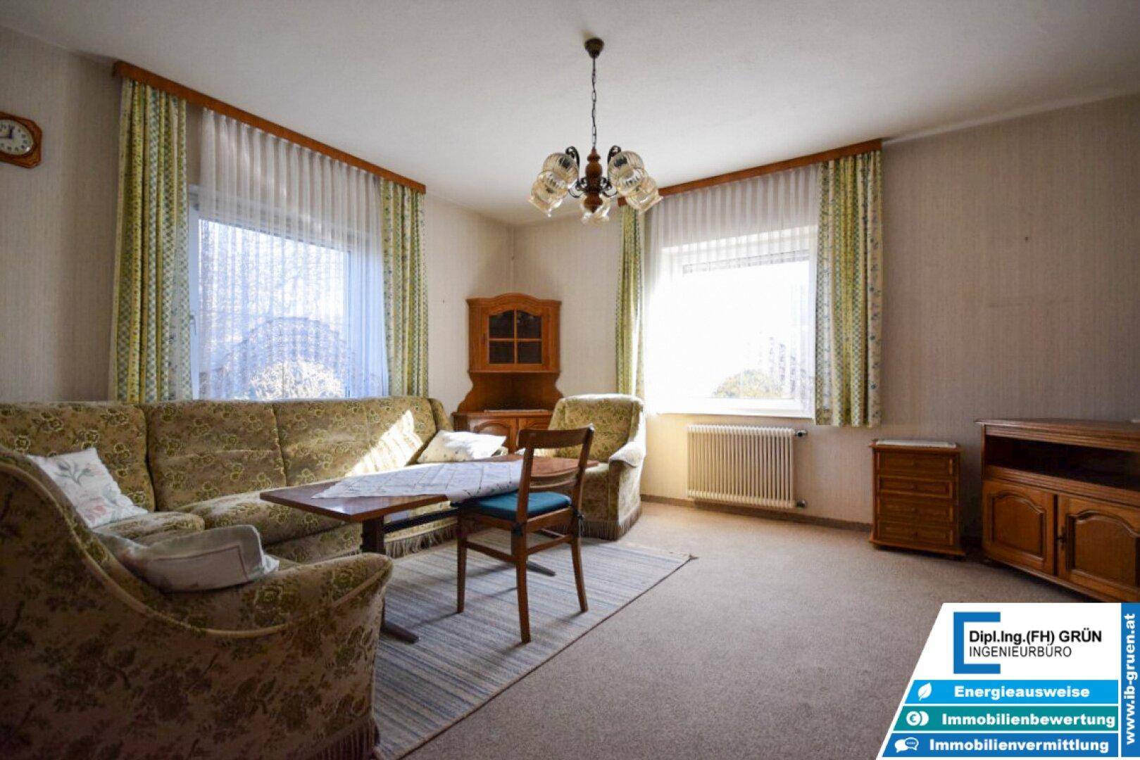 Helles Wohnzimmer mit zwei Sofas, Teppich und großem Fenster.