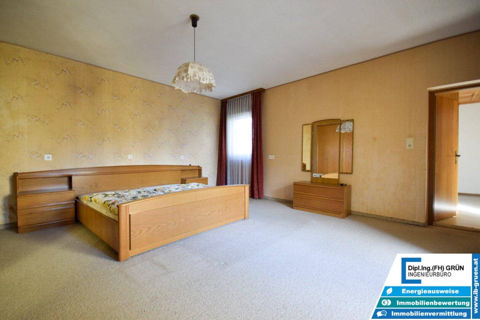 Geräumiges Schlafzimmer mit Doppelbett, Schminktisch und Teppichboden.