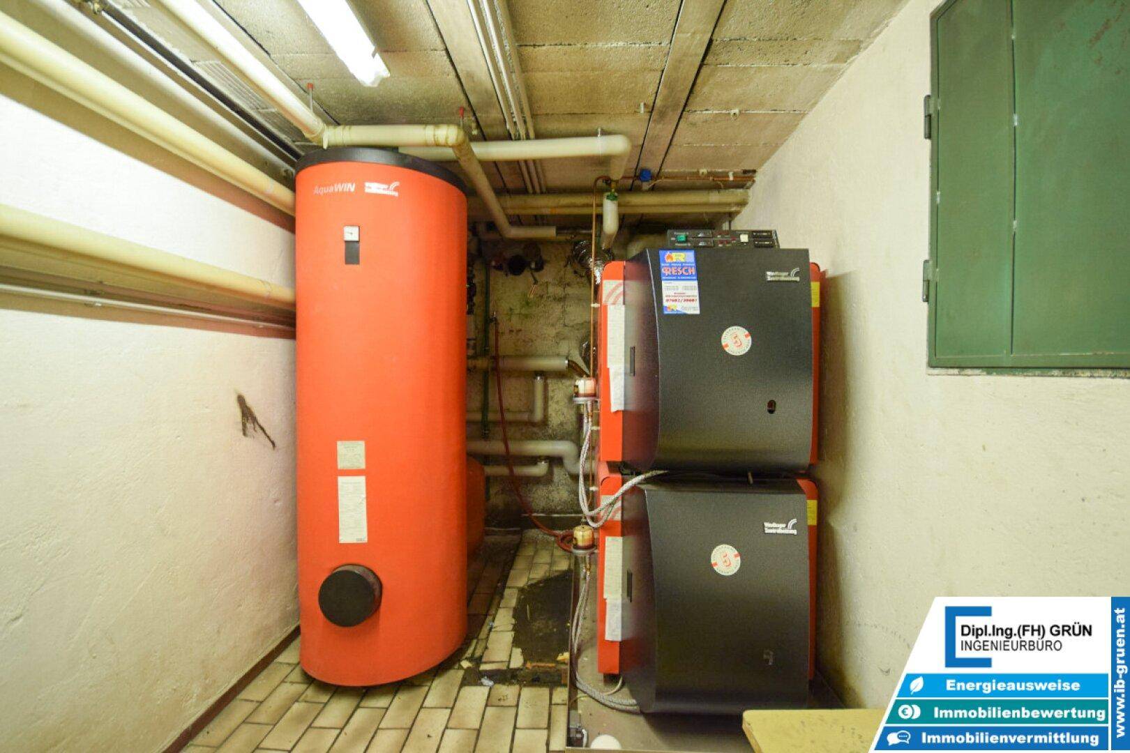 Technikraum im Keller mit Warmwasserspeicher und Heizungsanlagen für das Gebäude.