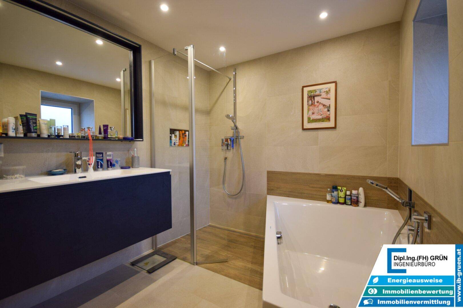 Modernes Badezimmer mit Badewanne, Duschkabine, Doppelwaschbecken und beigen Fliesen.