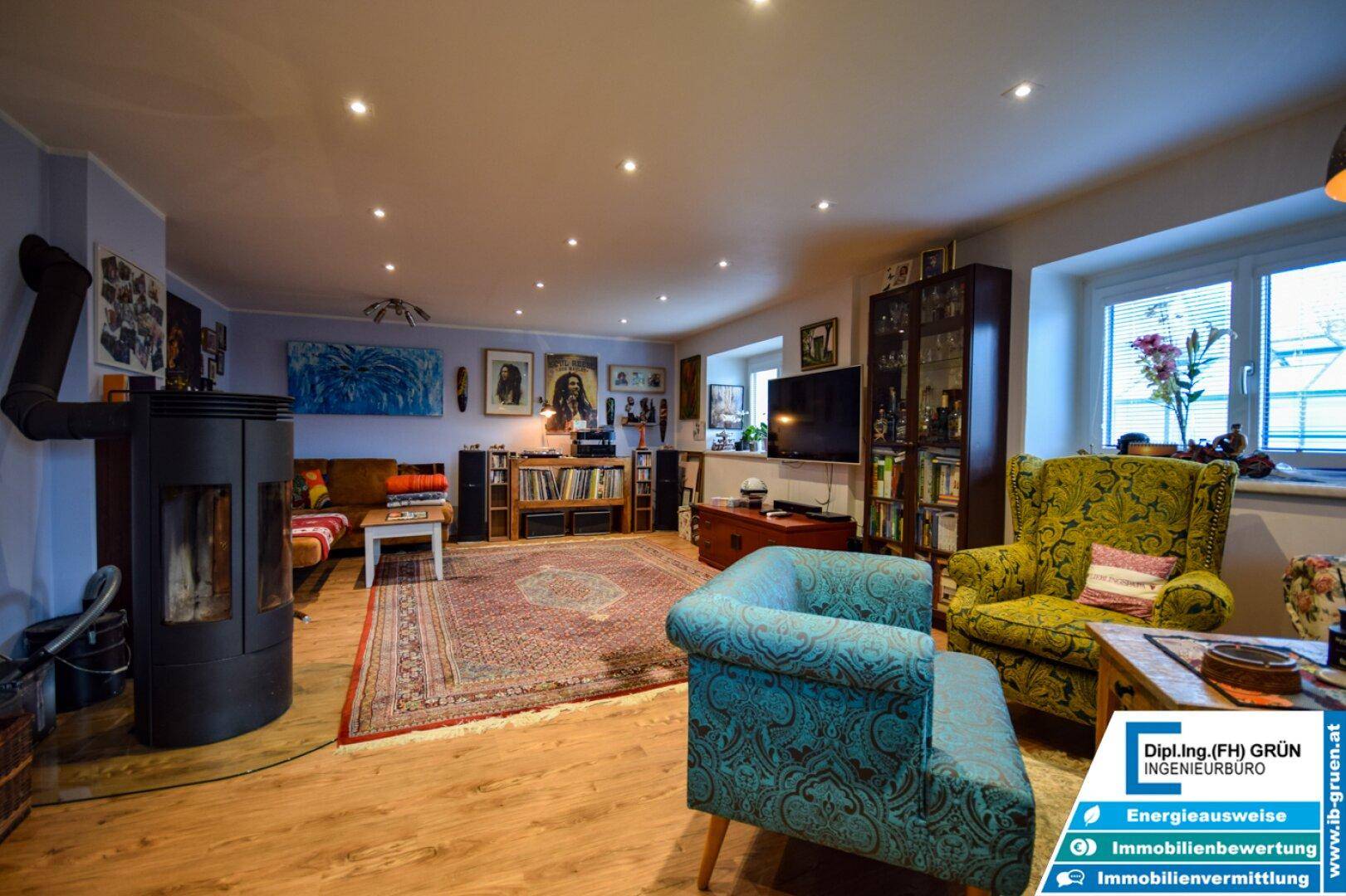 Geräumiges Wohnzimmer mit Holzofen, bequemen Sitzgelegenheiten und vielfältiger Dekoration.