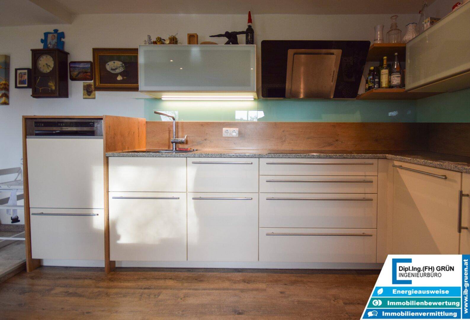 Funktionale Küche mit integriertem Geschirrspüler, Spüle und Holz-Arbeitsplatte.