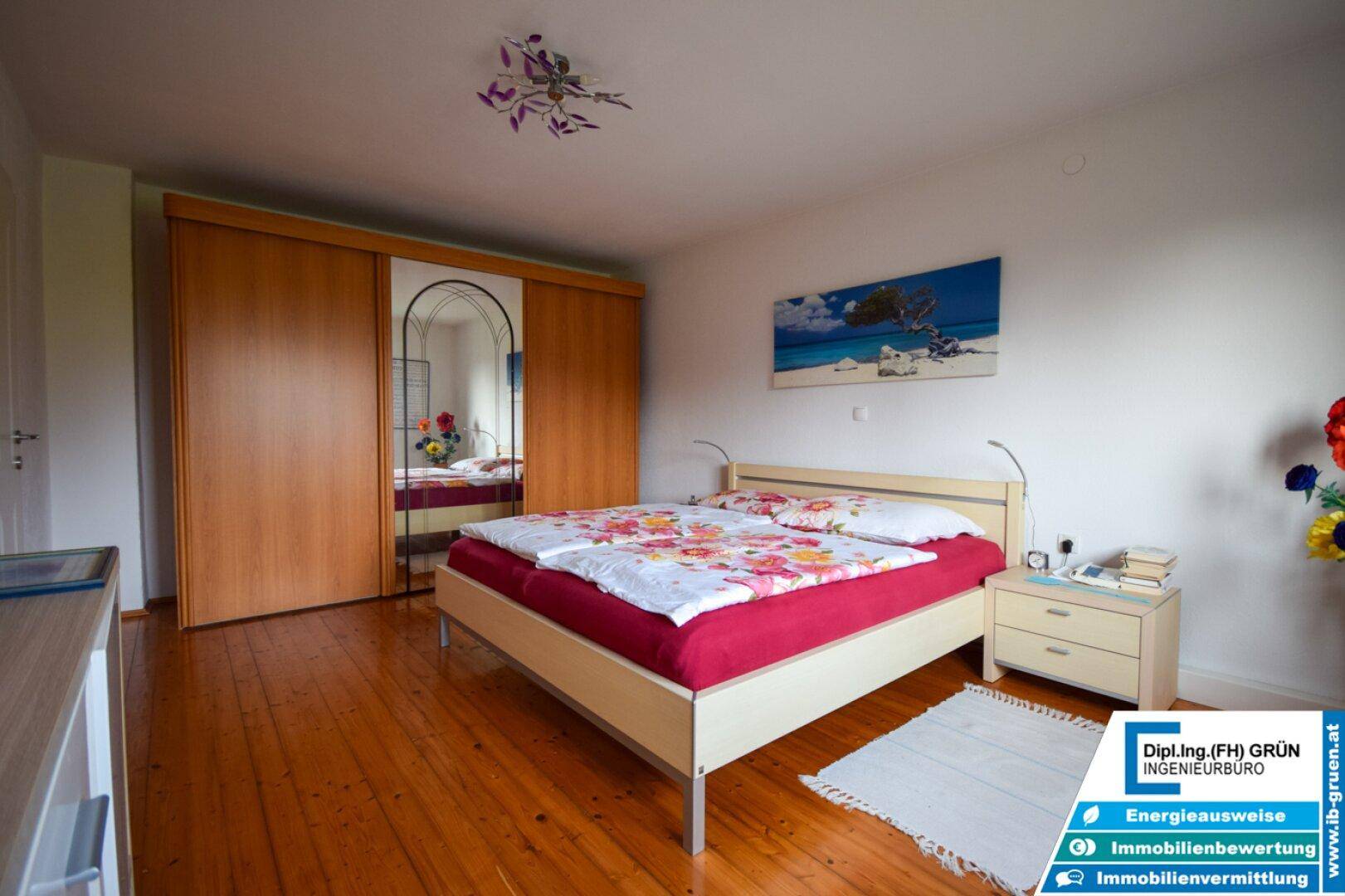 Schlafzimmer mit Doppelbett, Holzboden und großem Kleiderschrank mit Spiegeltür, hell und freundlich.