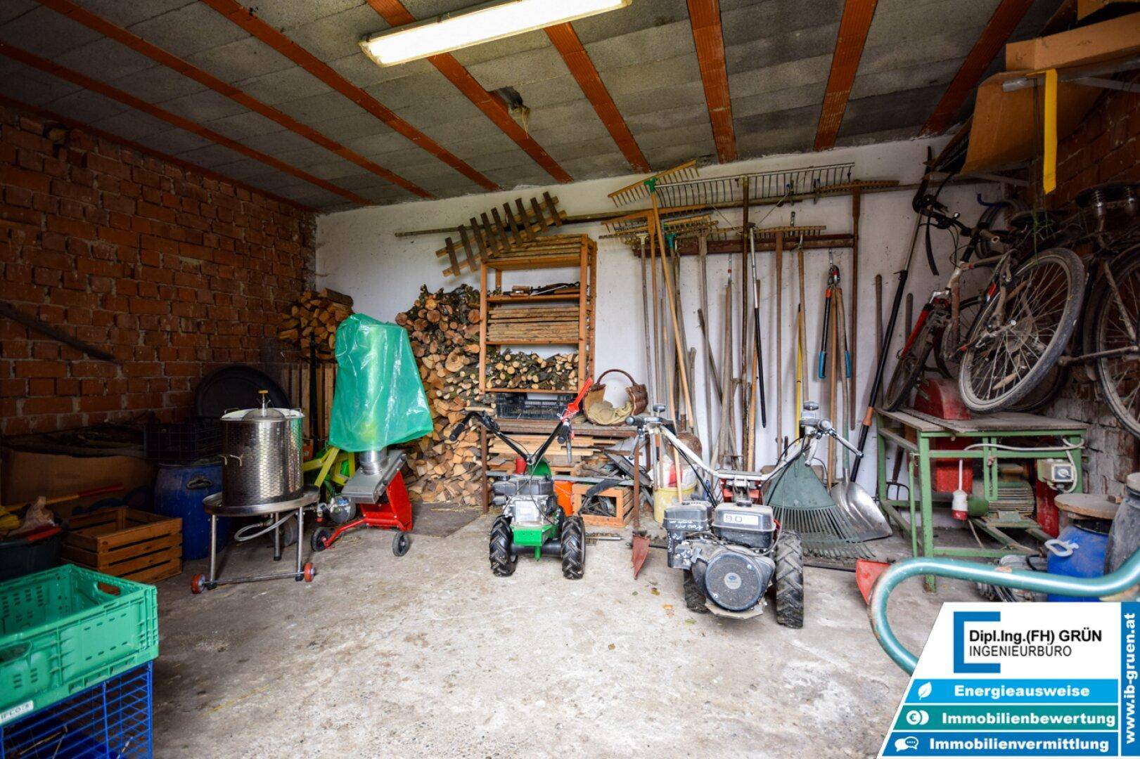 Geräumiger Lagerraum oder Werkstatt mit Werkzeugen, Geräten und gestapeltem Brennholz, sehr funktional.