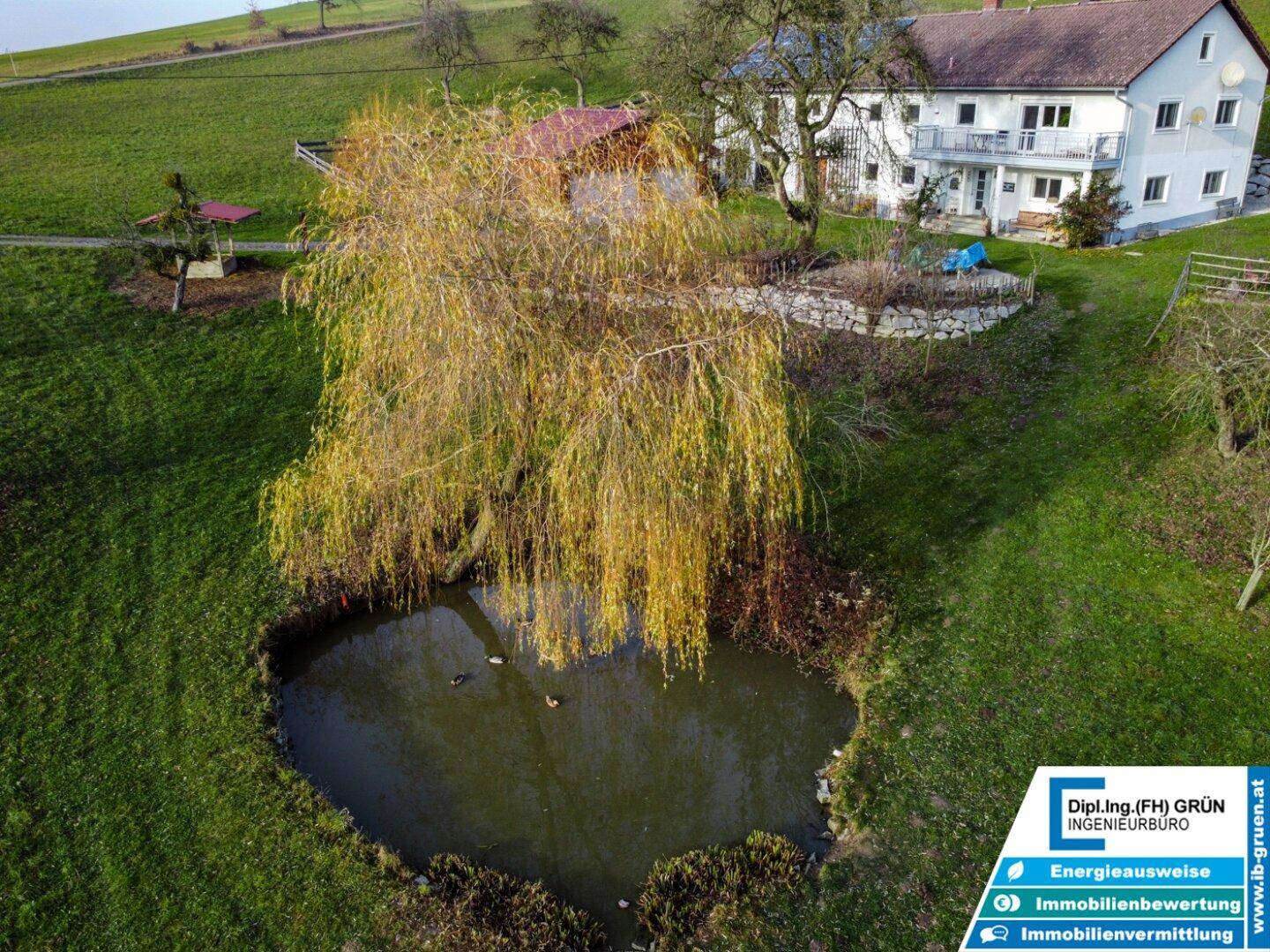 Luftaufnahme des Anwesens mit Wohnhaus, Teich und weitläufigen grünen Feldern in ländlicher Umgebung.