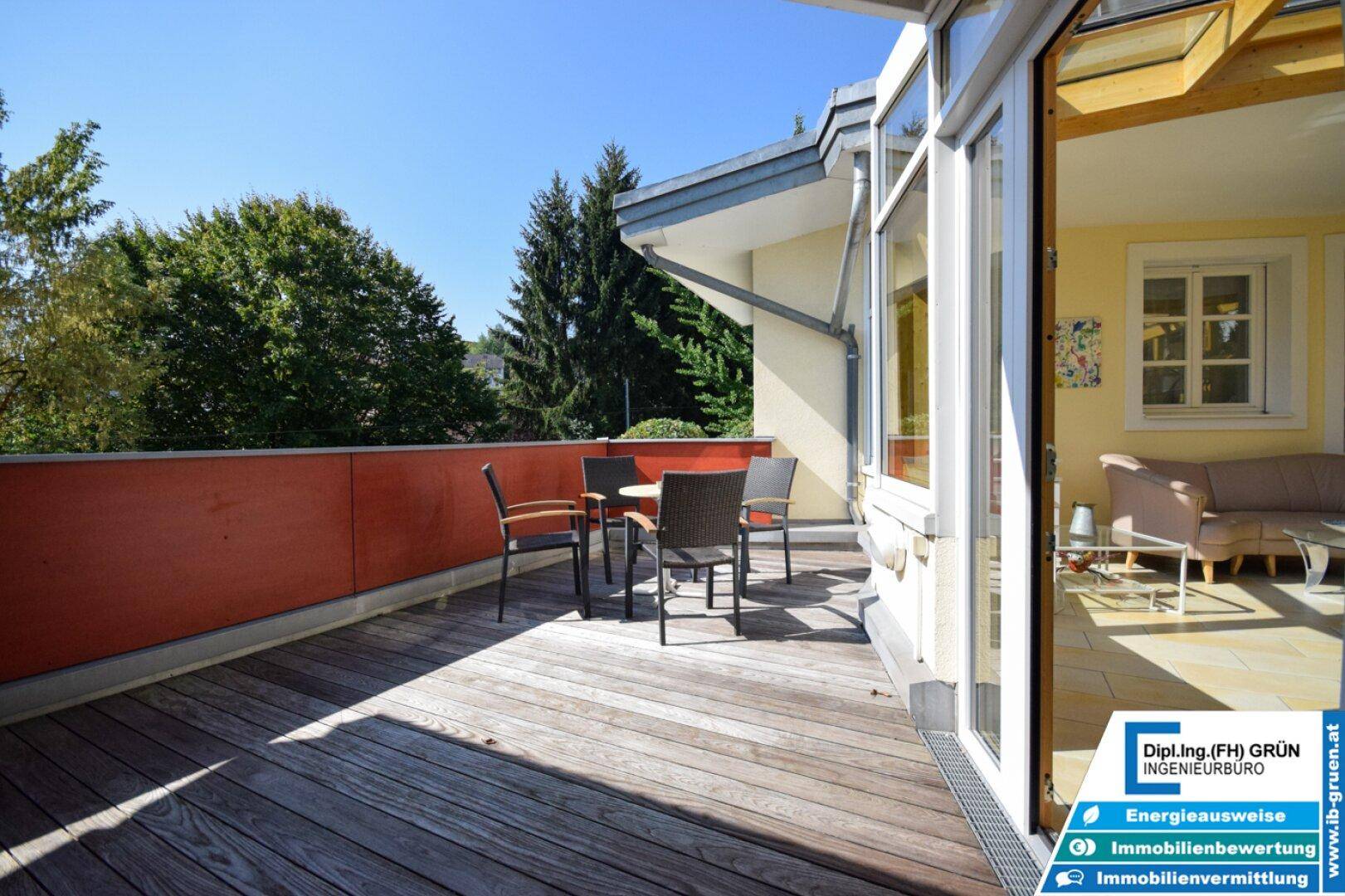 Geräumige Holzterrasse mit Sitzgelegenheiten und Blick ins Grüne, ideal für Entspannung im Freien.
