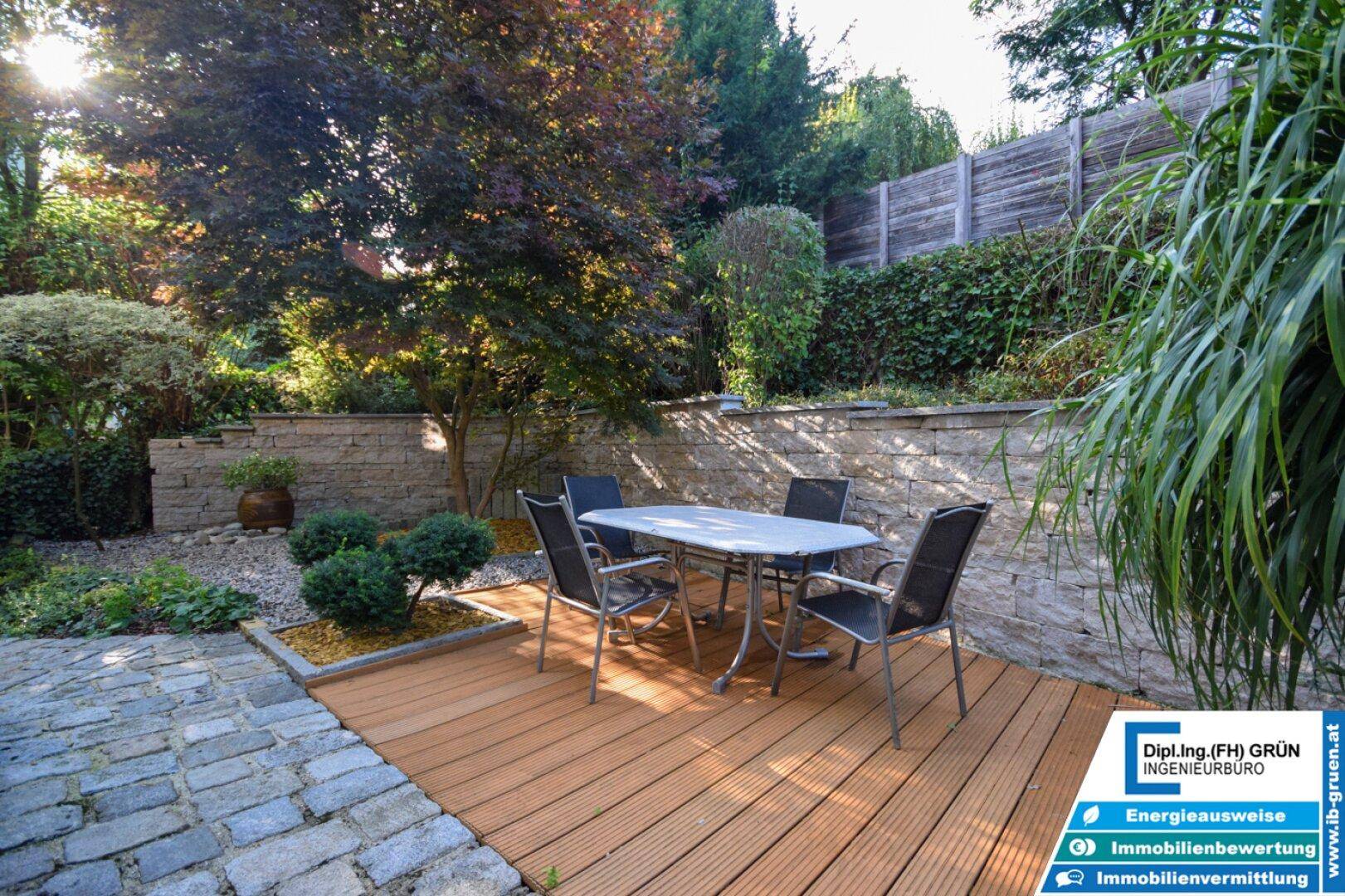 Gemütliche Terrasse mit Holzboden, Steinterrasse und Sitzgelegenheiten im Garten.