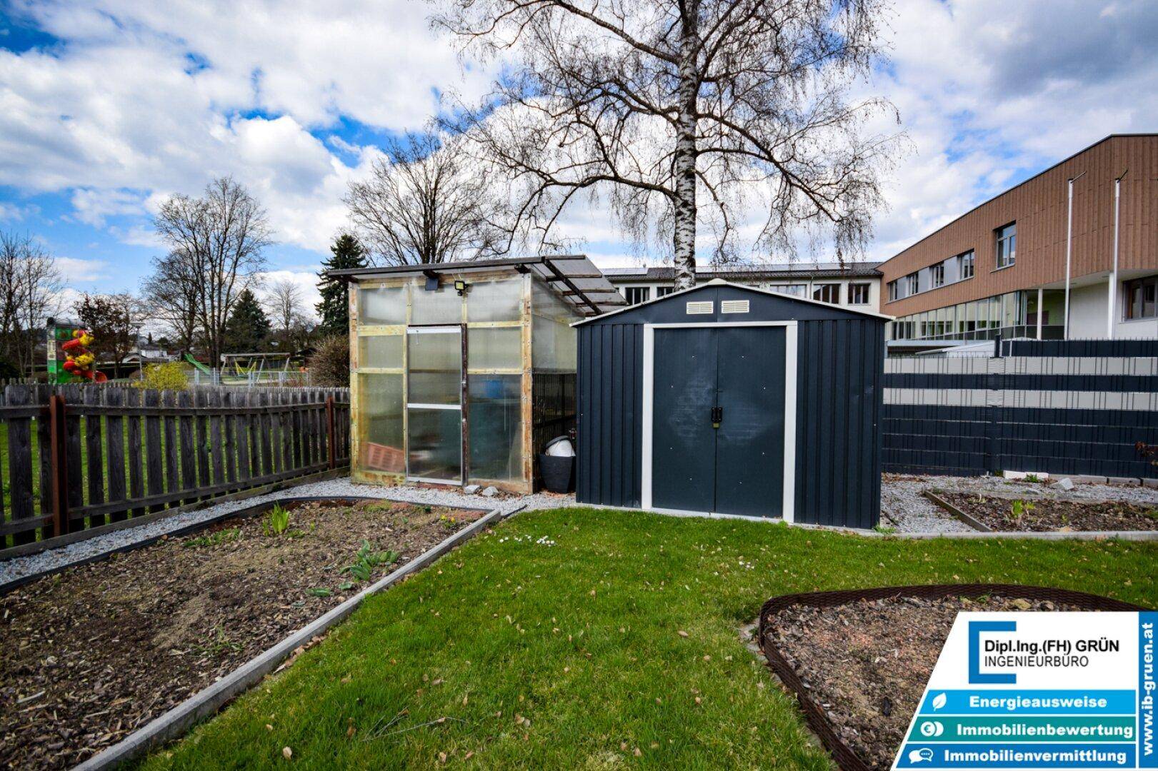 Gartenbereich mit Gewächshaus und einem praktischen Geräteschuppen für Gartengeräte.