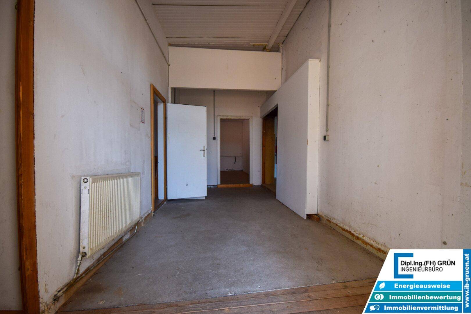 Großer, leerer Raum mit Betonboden und Heizkörper, der auf eine neue Nutzung wartet.
