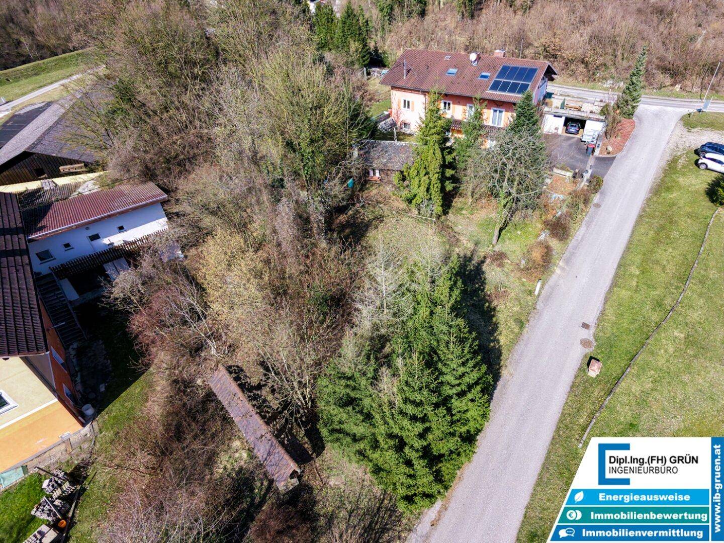 Panoramablick aus der Luft auf das Grundstück, angrenzende Häuser und eine Zufahrtsstraße.