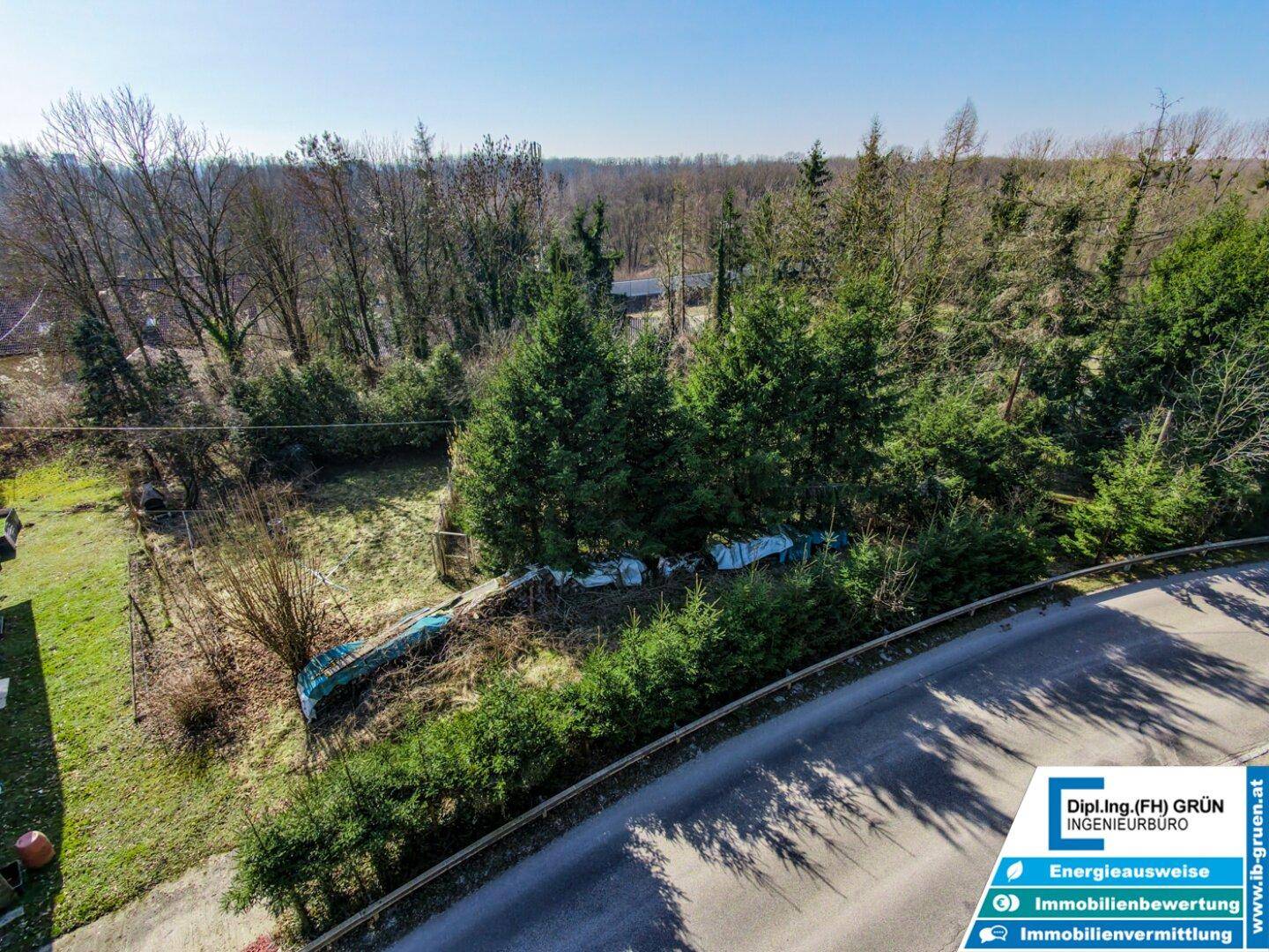 Weitläufige Luftaufnahme eines Grundstücks mit dichter Vegetation und angrenzender Straße.