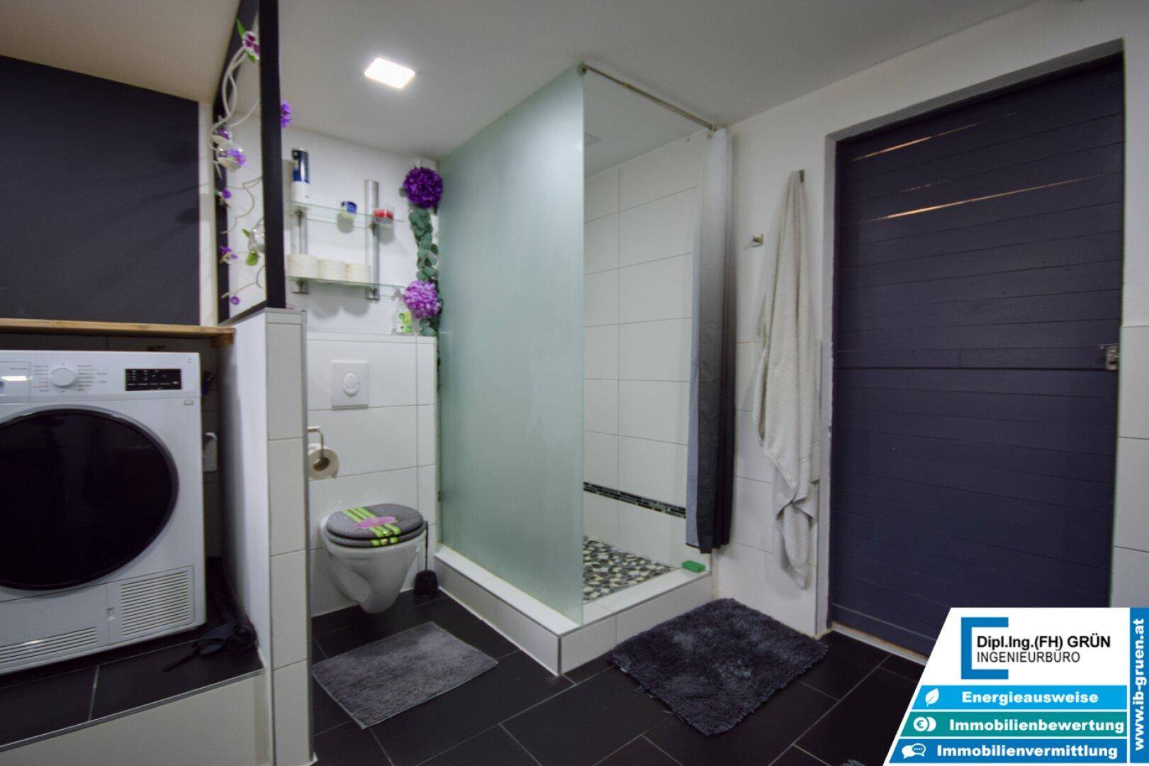 Badezimmer im Untergeschoss mit Dusche, Toilette und Waschmaschine.