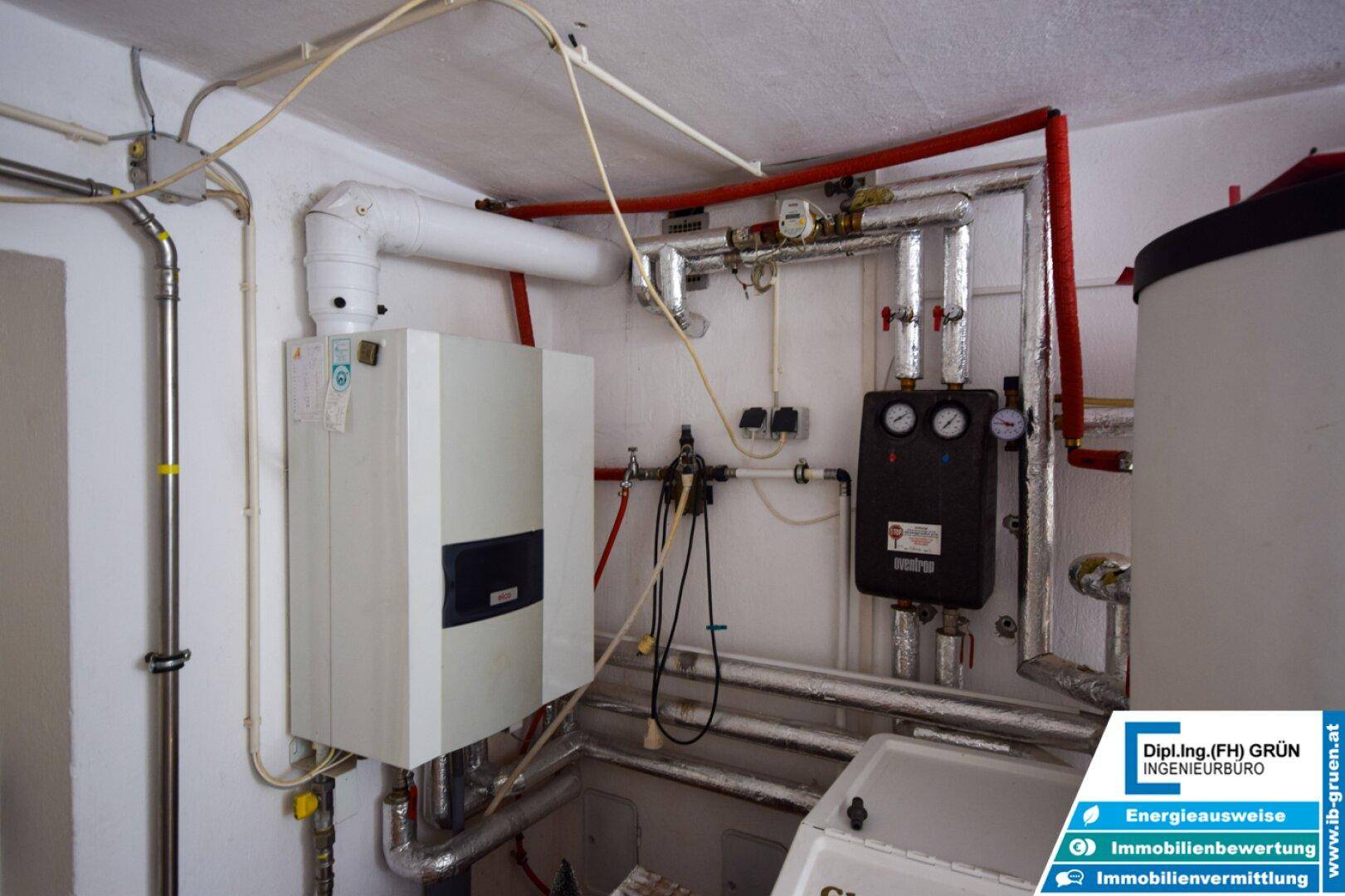 Heizungsanlage im Keller mit Boiler und komplexen Rohrleitungen.