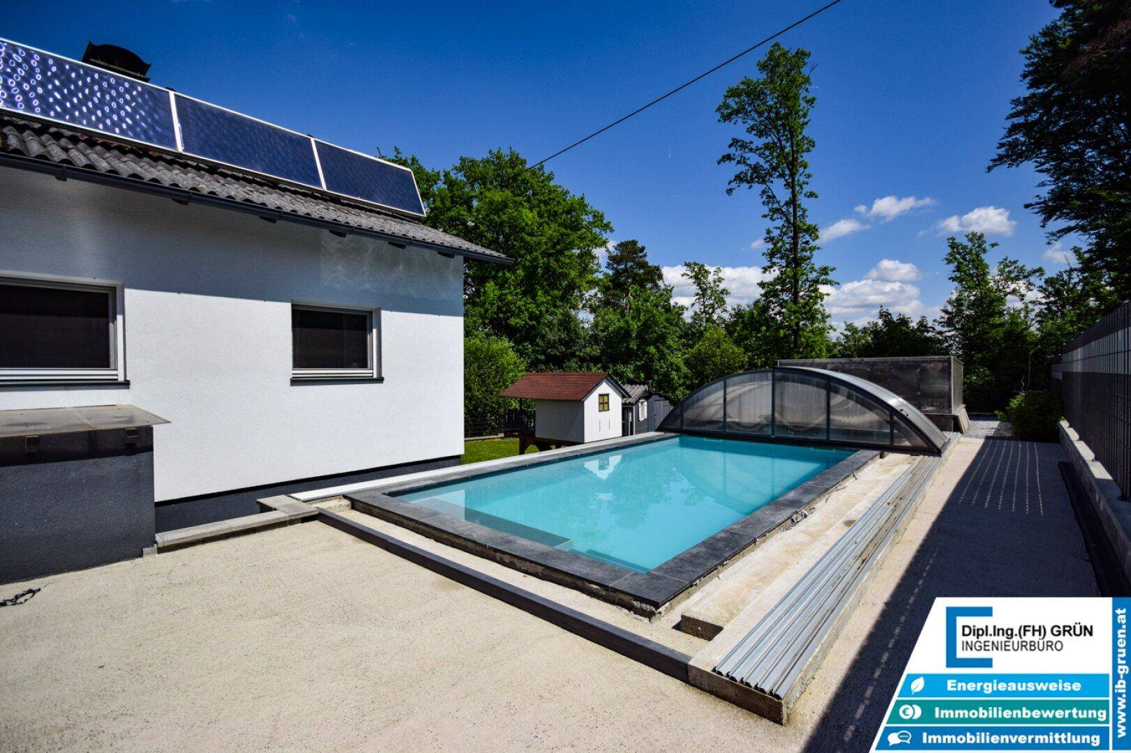 Außenbereich mit großem Pool, Solaranlage auf dem Dach und umgebender Natur.