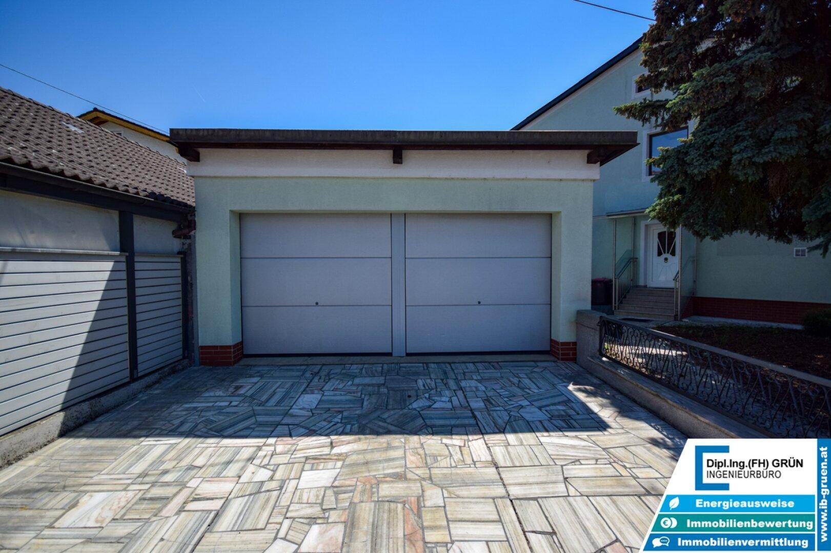 Doppelgarage mit gepflasterter Einfahrt und direktem Zugang zum Haus.