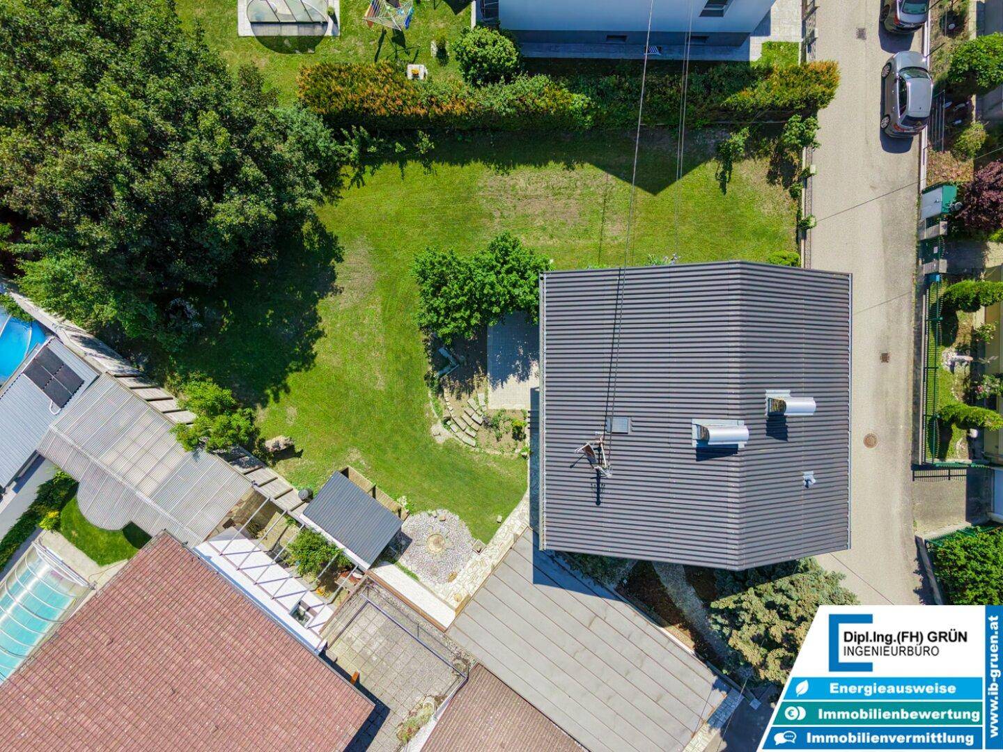 Luftaufnahme des Grundstücks mit Haus, Garten und umliegender Bebauung.