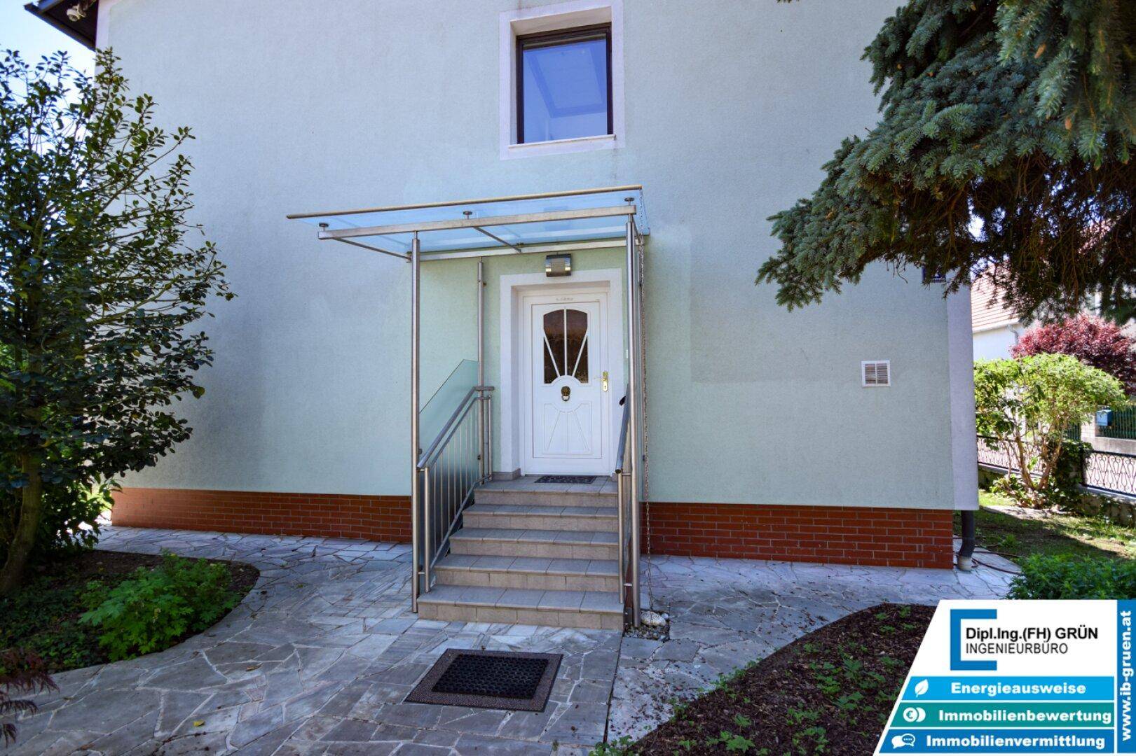 Eingangsbereich des Hauses mit überdachtem Vordach und Treppe.