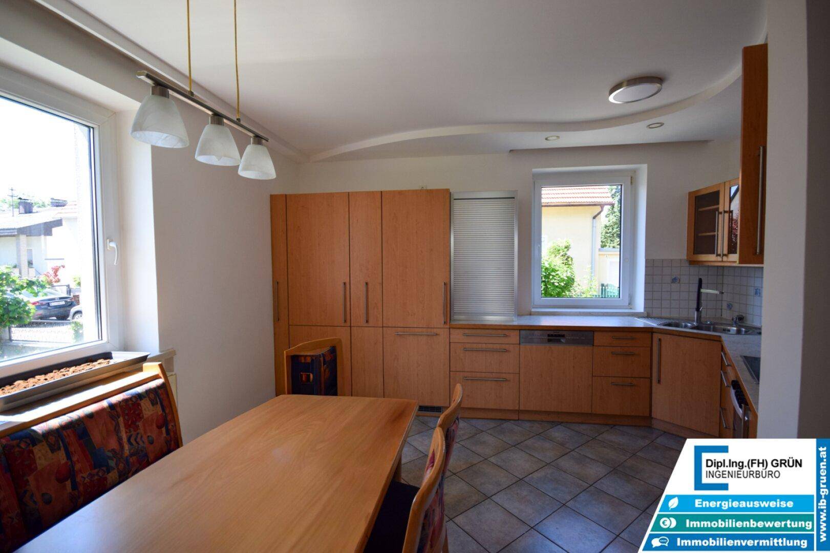 Geräumige Wohnküche mit Holzmöbeln, Essbereich und viel Tageslicht.