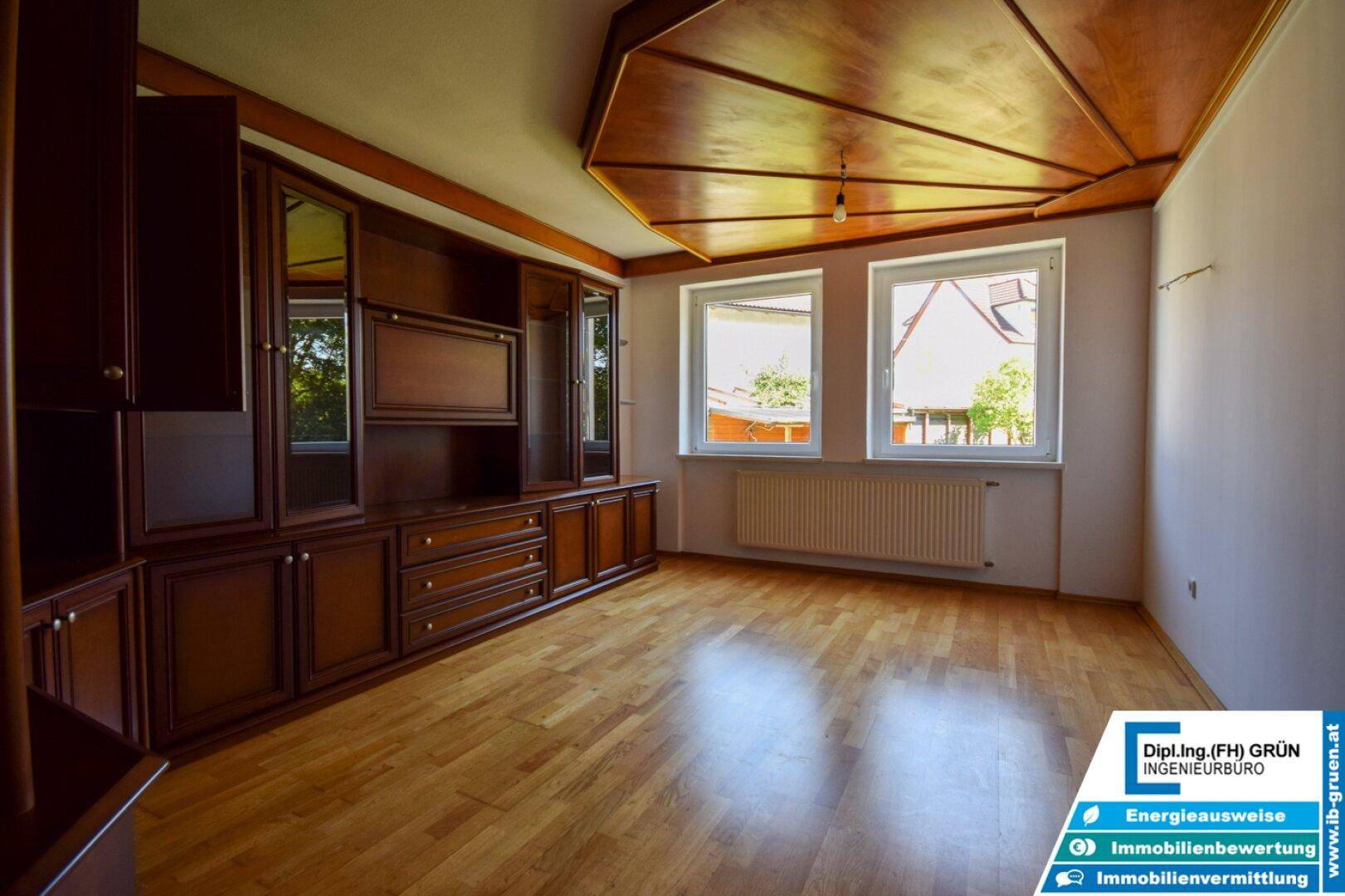 Geräumiges Schlafzimmer mit Parkettboden, Holzdecke und großem Einbauschrank.