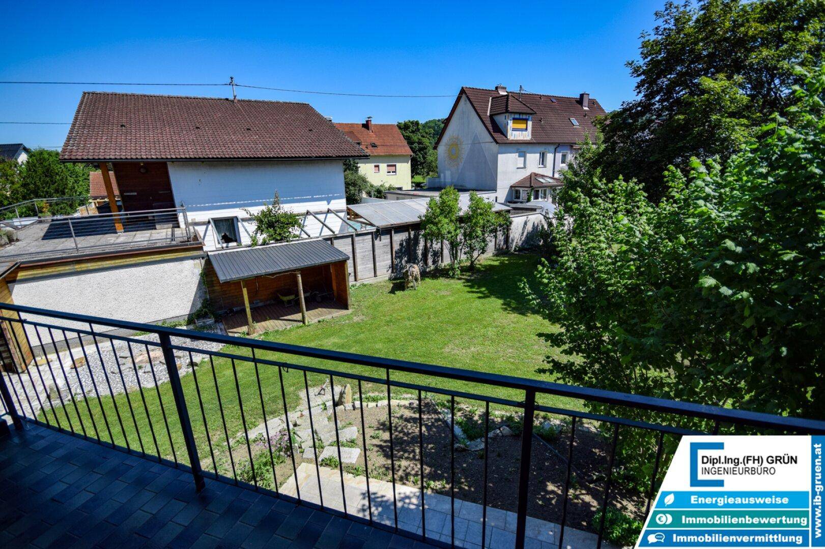 Balkon mit Blick auf den Garten und die umliegenden Häuser in sonniger Lage.