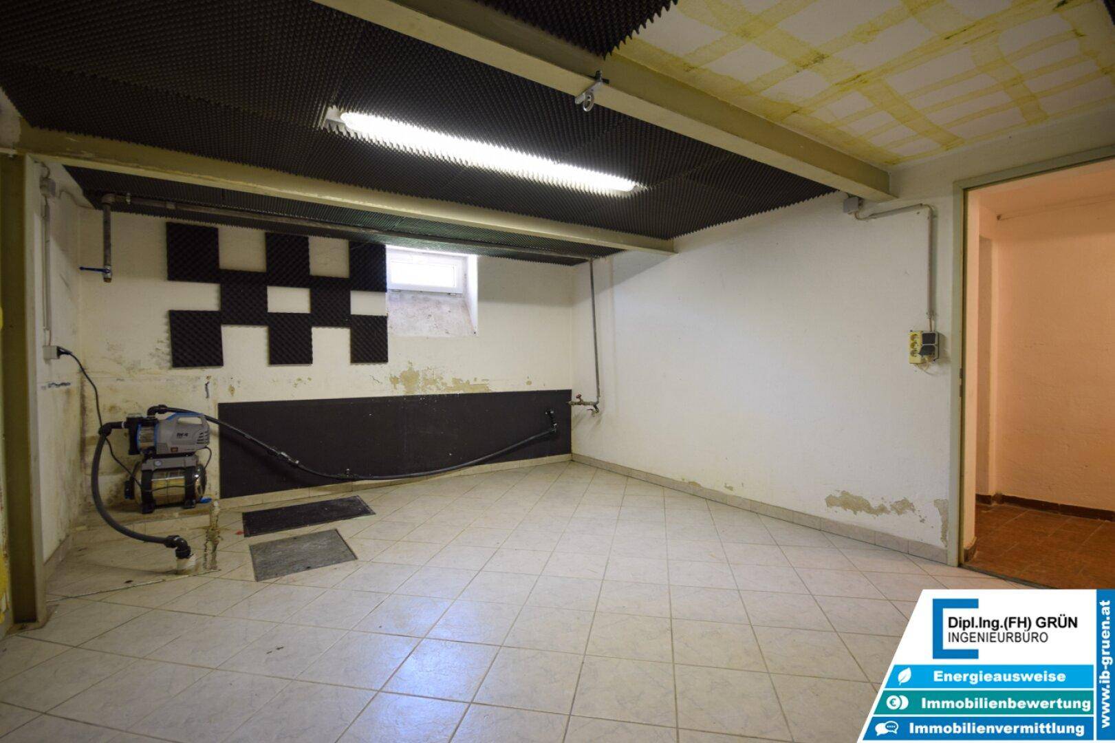 Kellerraum mit Fliesenboden und Schallschutzplatten an der Decke, praktisch und funktional.