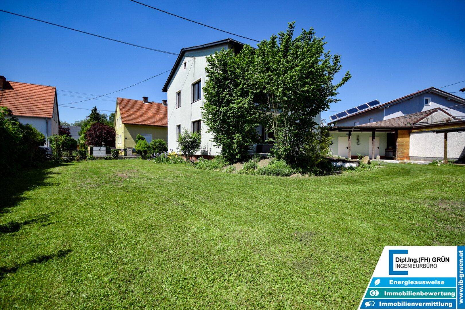Weitläufiger Garten mit gepflegtem Rasen und dem Haus im Hintergrund.
