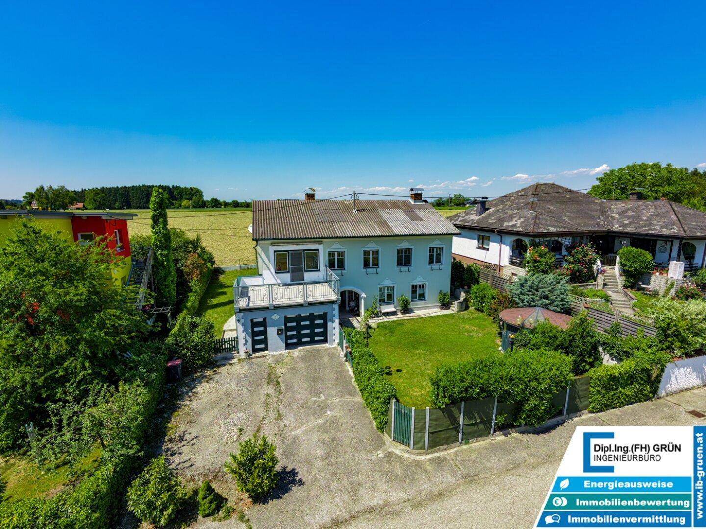 Weitwinkel-Luftaufnahme des Hauses mit Zufahrt, Garten und angrenzenden Feldern.
