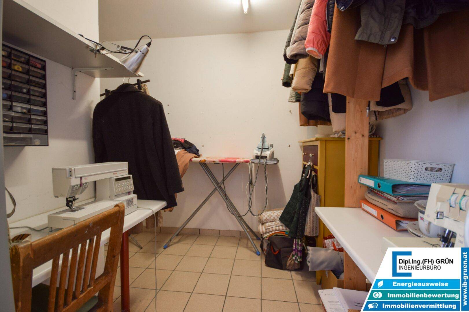 Praktischer Hauswirtschaftsraum mit Nähmaschinen, Bügelbrett und Stauraum für Kleidung.